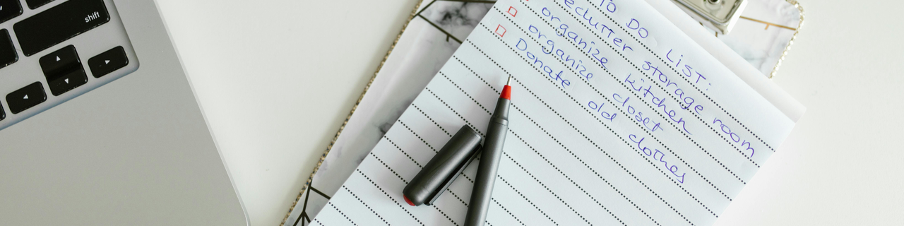 Aufgeräumter Schreibtisch mit handschriftlicher Häkchen-Liste